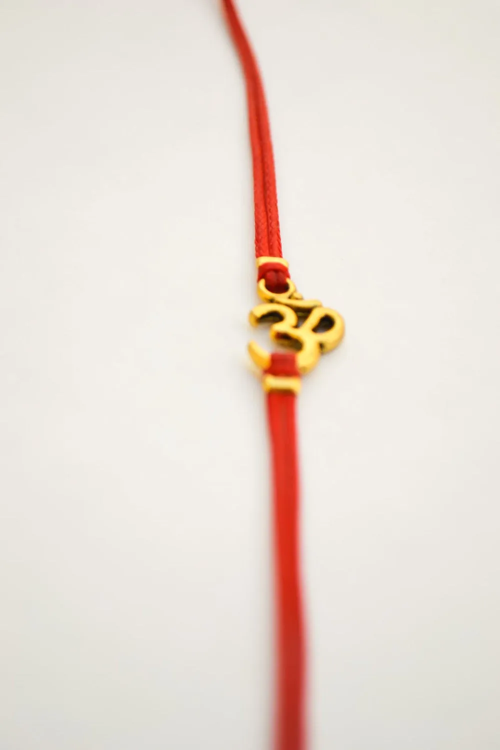 Wrapped red bracelet with gold tone Om charm, yoga jewelry for her